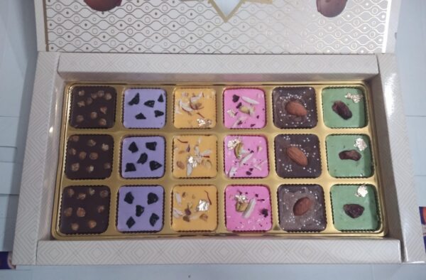 Premium Assorted Chocolate Box: 18 chocolates in 6 flavors—Butterscotch, Blueberry, Rasmalai, Rose, Almond, and Paan. A perfect luxury treat.